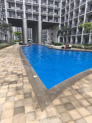 a large blue swimming pool in front of a building at MOA Staycation in Manila