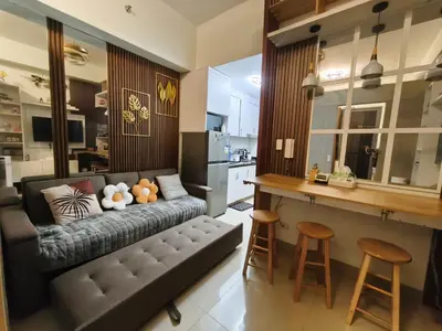 a living room with a couch and a kitchen at MOA Staycation in Manila