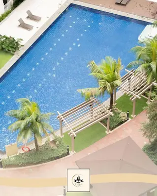 a large swimming pool with a bench and palm trees at Eutopia Vista- 2 Bedroom Condo in SMDC Bloom in Manila