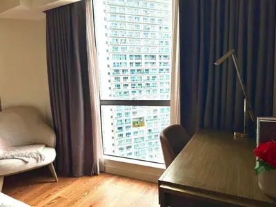 a living room with a large window with a building at Mesmerizing Twin Bed with Rockwell View in Manila