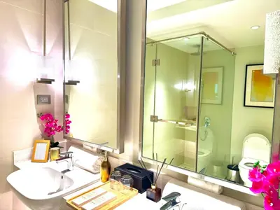 a bathroom with a sink and a glass shower at Mesmerizing Twin Bed with Rockwell View in Manila