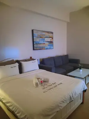a bedroom with a large bed with a blue couch at Cluster 4 7G in Manila