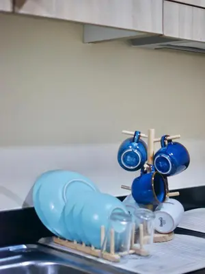 a bunch of blue dishes on a drying rack next to a sink at Whimsy Stay in Manila