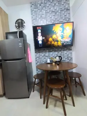 a dining room with a table and a refrigerator at Shore Residences at Mall Of Asia Complex - by Staycation Empire in Manila