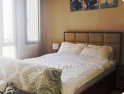 a bedroom with a large bed with white sheets at A Home Away From Home in Manila