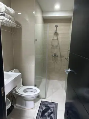 a bathroom with a shower and a toilet and a sink at A Home Away From Home in Manila