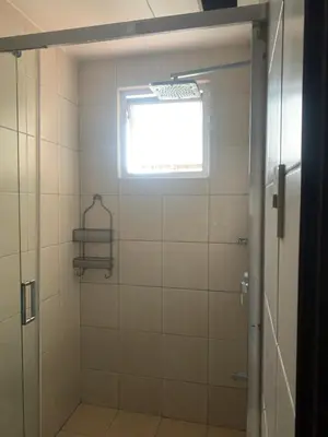 a bathroom with a shower with a window at Birch tower Condominium in Manila
