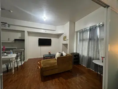 a living room with a couch and a tv and a table at Robinson's Place Residences, in Manila