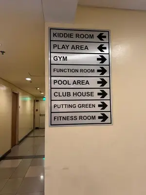 a sign hanging on a wall in a hallway at Robinson's Place Residences, in Manila
