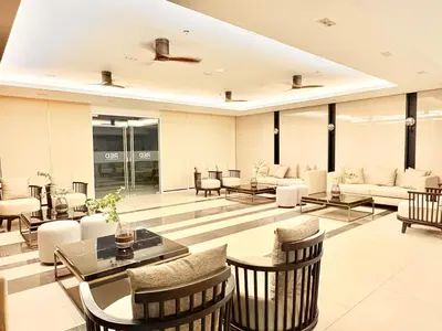 a lobby with tables and chairs in a building at Trouvaille in Red Residences in Manila