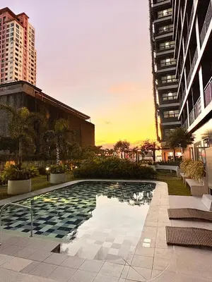 a pool in the middle of a city with buildings at Trouvaille in Red Residences in Manila