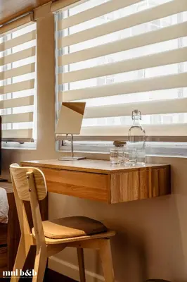 a desk with a lamp and a chair in front of a window at UP TO 6 PAX! Spacious Loft 2 BR near High Street, BGC Fort Victoria The Fort, Taguig City in Manila
