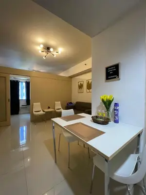 a kitchen and living room with a table and chairs at Sea Residences 1BR Stays - Near Airport & MOA Pasay in Manila