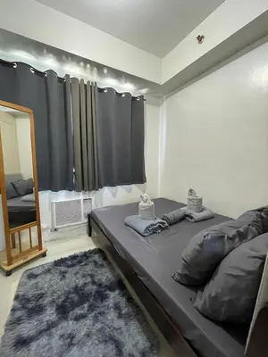 a large bed in a room with a mirror and a mirror at Sea Residences 1BR Stays - Near Airport & MOA Pasay in Manila