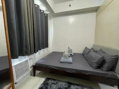 a small bed in a room with a window at Sea Residences 1BR Stays - Near Airport & MOA Pasay in Manila
