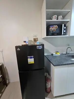 a black refrigerator in a kitchen with a counter at Shore Residences Sm mall of asia Marc in Manila