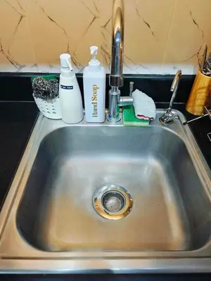 a kitchen sink with cleaning products on top of it at Cozy Modern 1BR Light Residences with 55 inches 4K TV in Manila