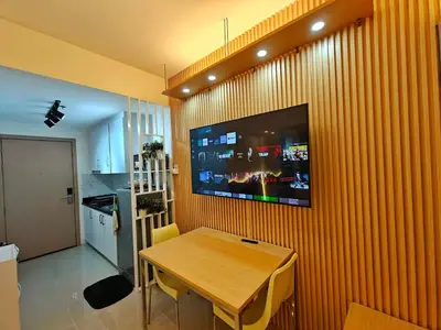 a dining room with a table and a tv on a wall at Cozy Modern 1BR Light Residences with 55 inches 4K TV in Manila