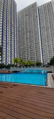 a large building with a blue pool in front of it at SMDC Jazz Residence by rhoda kotani in Manila