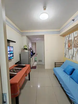 a room with a bed and a table in it at Sea Residences near moa Glenda in Manila