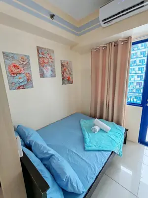 a bedroom with a blue bed in a room at Sea Residences near moa Glenda in Manila