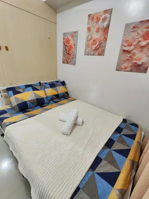 a bedroom with a bed with two towels on it at Sea Residences near moa Glenda in Manila