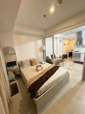 a bedroom with a large bed and a living room at Azure Urban Resort Residences in Manila