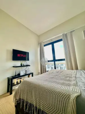 a bedroom with a bed and a large window at Light residence in Manila