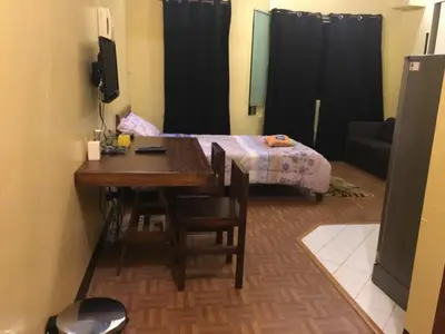 a small room with a table and a bed at Studio Condominium near the US Embassy in Manila in Manila
