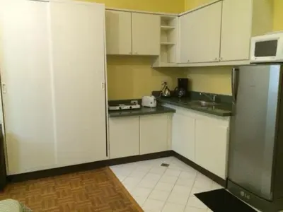 a kitchen with white cabinets and a stainless steel refrigerator at Studio Condominium near the US Embassy in Manila in Manila