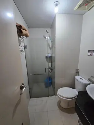 a bathroom with a shower with a toilet and a sink at Newport Staycation in Manila