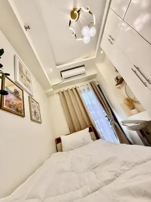 a bedroom with a white bed and a window at Cozy and Comfy Retreat with Balcony in Manila