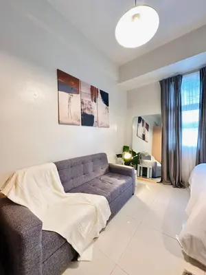 a living room with a couch and a bed at 101 Newport Boulevard near NAIA Terminal 3 in Manila
