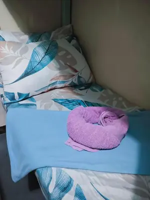 a purple towel laying on top of a bed at Bunkaroo in Manila