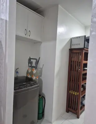 a small kitchen with a stove and a shelf at 1BR Retro-styled Condo unit in BGC, Taguig City in Manila