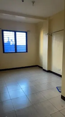 an empty room with a large window and a tile floor at Studio Type Manila in Manila