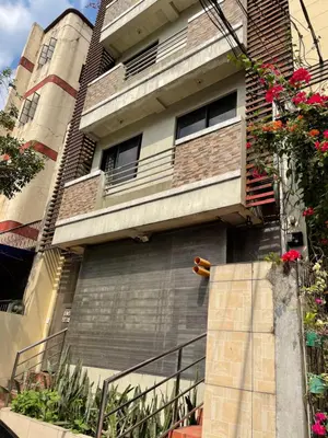 an apartment building with a metal garage door and flowers at Studio Type Manila in Manila
