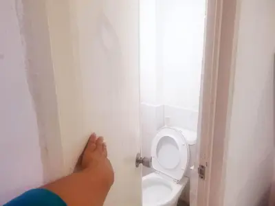 a person standing in a bathroom with a toilet at Fernica Boarding House in Bancal