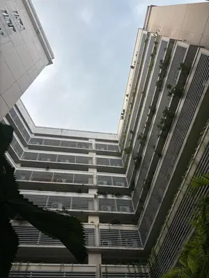 a tall building with many windows and plants at Family Suite-150Newport Boulevard Southwing in Manila