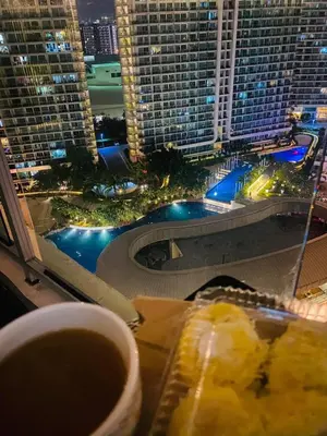 a plate of food with a view of a city at night at Azure Urban Resort Residence A51 in Manila