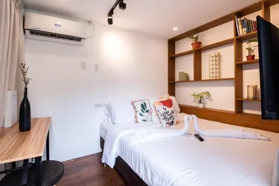 a bedroom with two beds and a desk and shelves at Container Home Mandaluyong N02 in Manila
