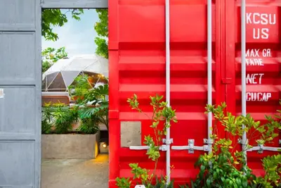 a red door with plants in front of a building at Container Home Mandaluyong N03 in Manila