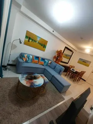 a living room with a blue couch and a table at Condotels by Mandolin Suite in Manila