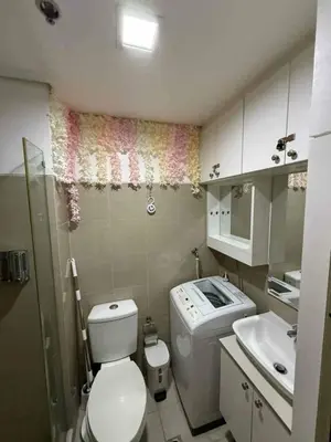 a small bathroom with a toilet and a sink at shore residences admin in Manila