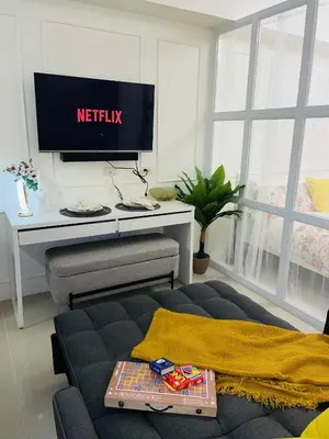a living room with a couch and a tv at ASV Condo Staycation SMDC Breeze in Manila