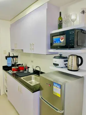 a kitchen with a sink and a microwave at ASV Condo Staycation SMDC Breeze in Manila