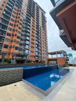 a swimming pool in front of a large building at LSB Modern Penthouse in Manila