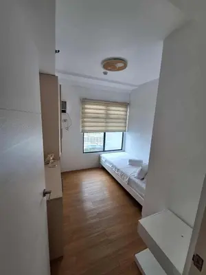 a small bedroom with a bed and a window at LSB Modern Penthouse in Manila