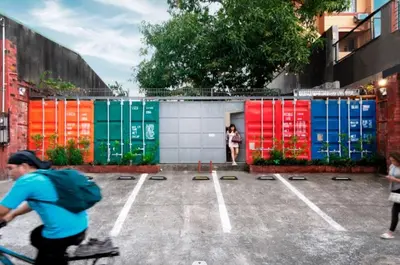 a man riding a bike in a parking lot withcolored containers at Container Home Mandaluyong N04 in Manila