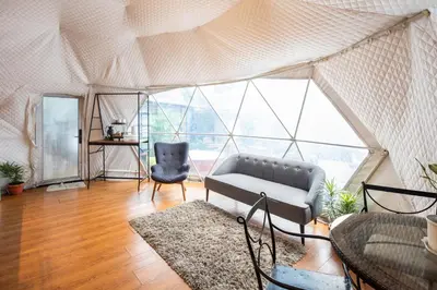 a living room with a couch and a chair in a tent at Container Home Mandaluyong N05 in Manila
